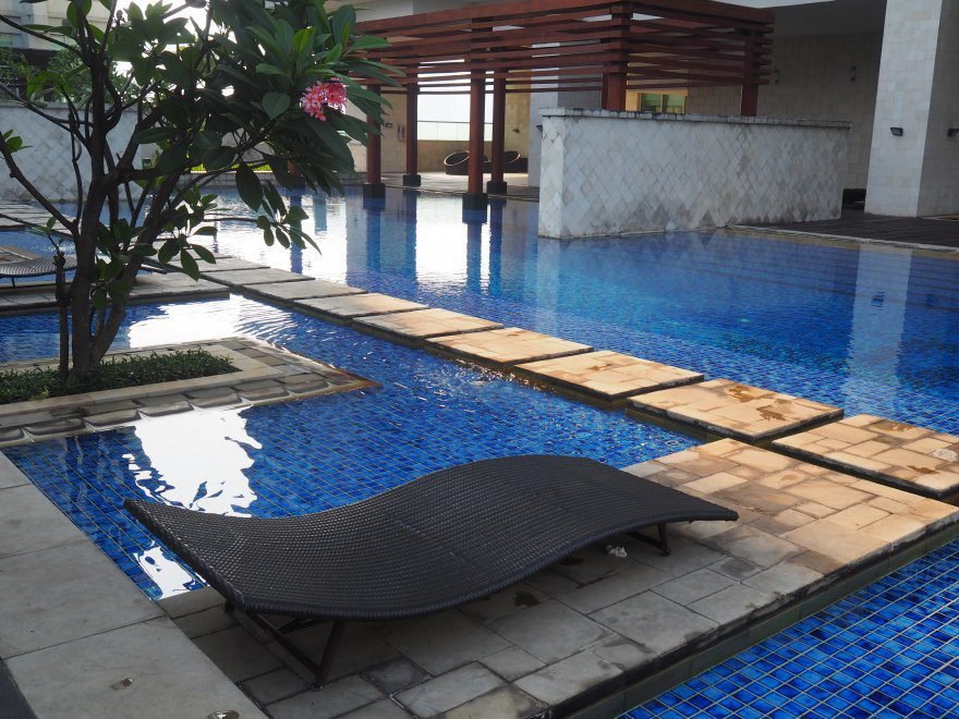 Sunbeds near pool in Denpasar Residence - Denpasar Residences Apartment